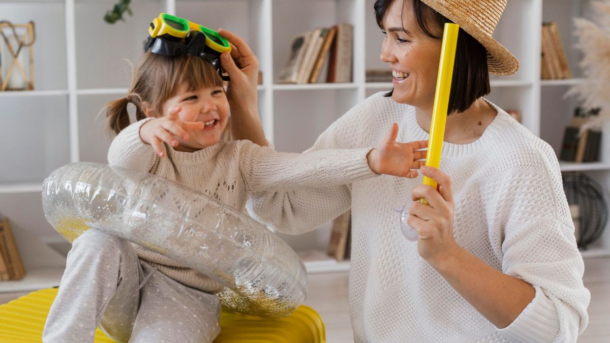 A young girl with autism shares a moment of fun and joy with her caregiver, playing with toys including a plastic buoyant ring.