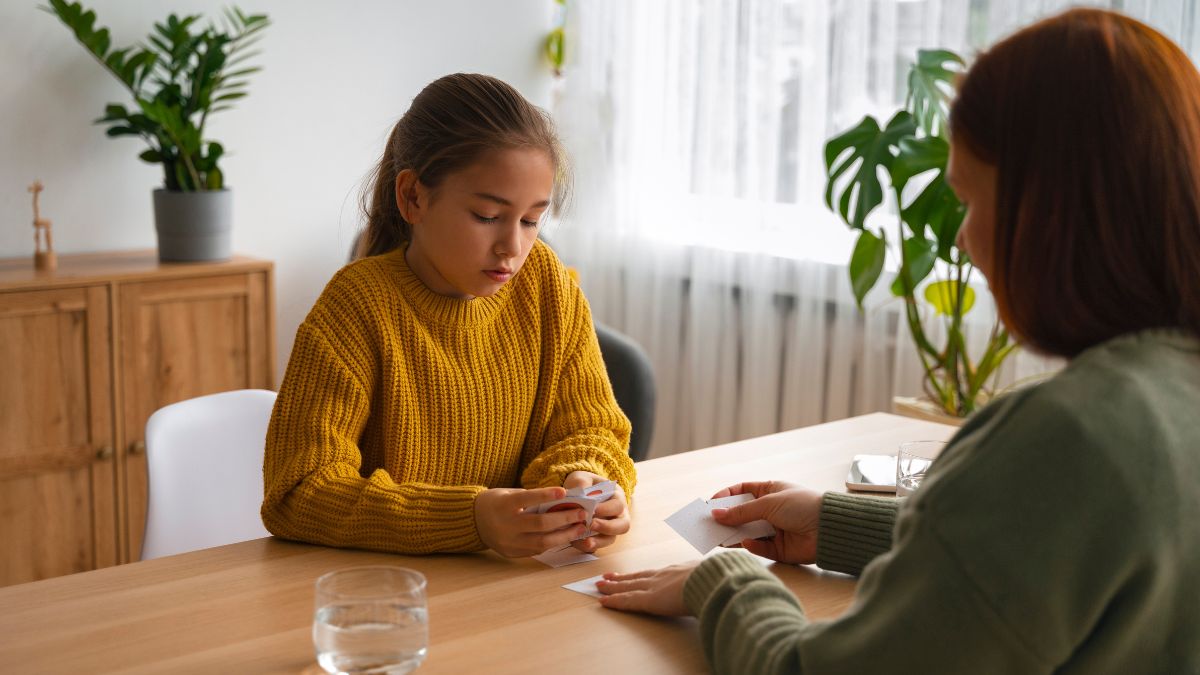 A young girl with her eyes downcast speaks to a concerned counselor, reflecting the stigma surrounding autism.