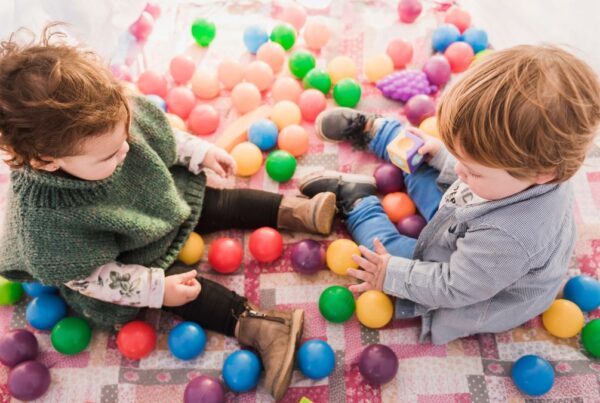Sensory items autism, two children play with circular sensory toys on the floor, captured from a top-view angle.
