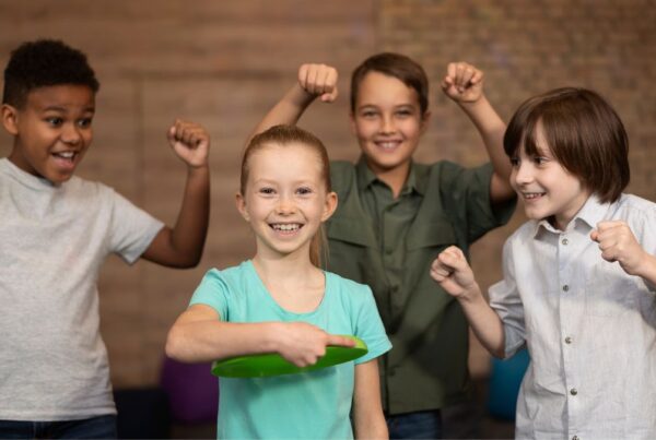 A young girl stands confidently at the center of a group, looking at the camera with a focused expression, demonstrating leadership skills.