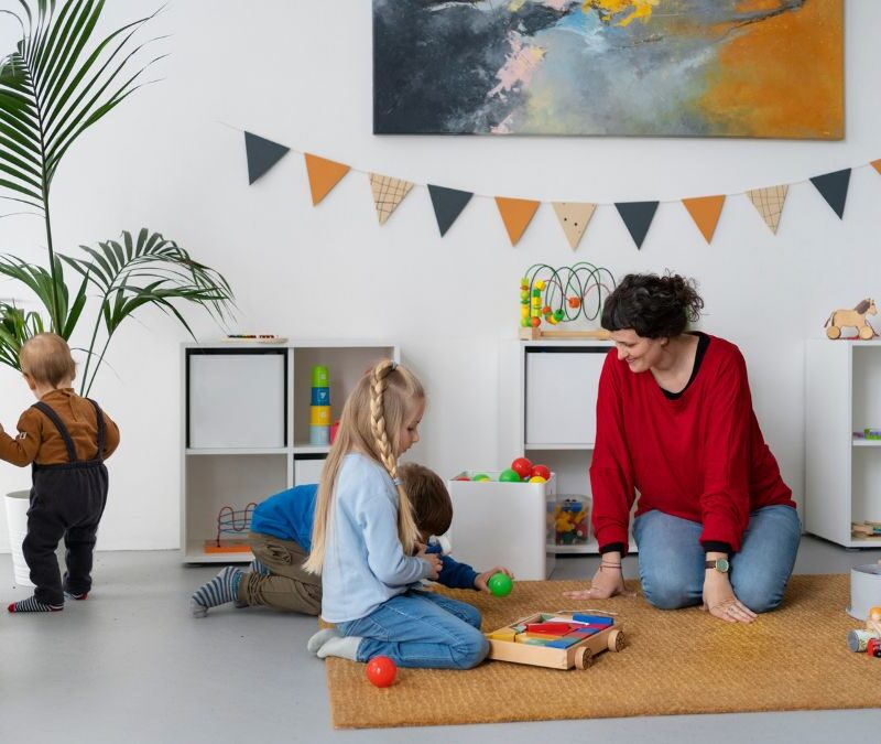 A child and therapist sit together in Floortime play, showing what supportive guidance looks like when choosing an ABA center.