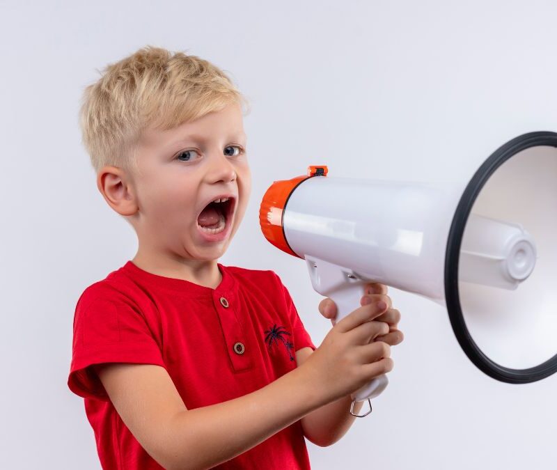 Echolalia autism, a child wearing a red shirt speaking through a megaphone.