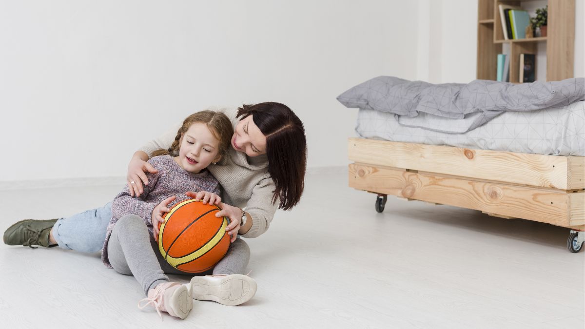 A parent guides her child through an indoor activity at home to support movement skill development during ABA therapy.